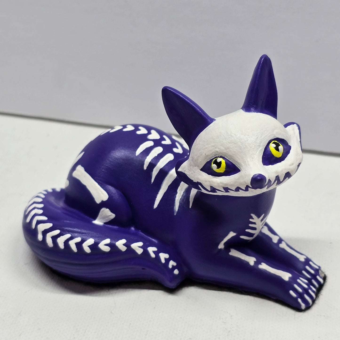 halloween fox, painted purple with white bone designs and featuring bright yellow pleading eyes
