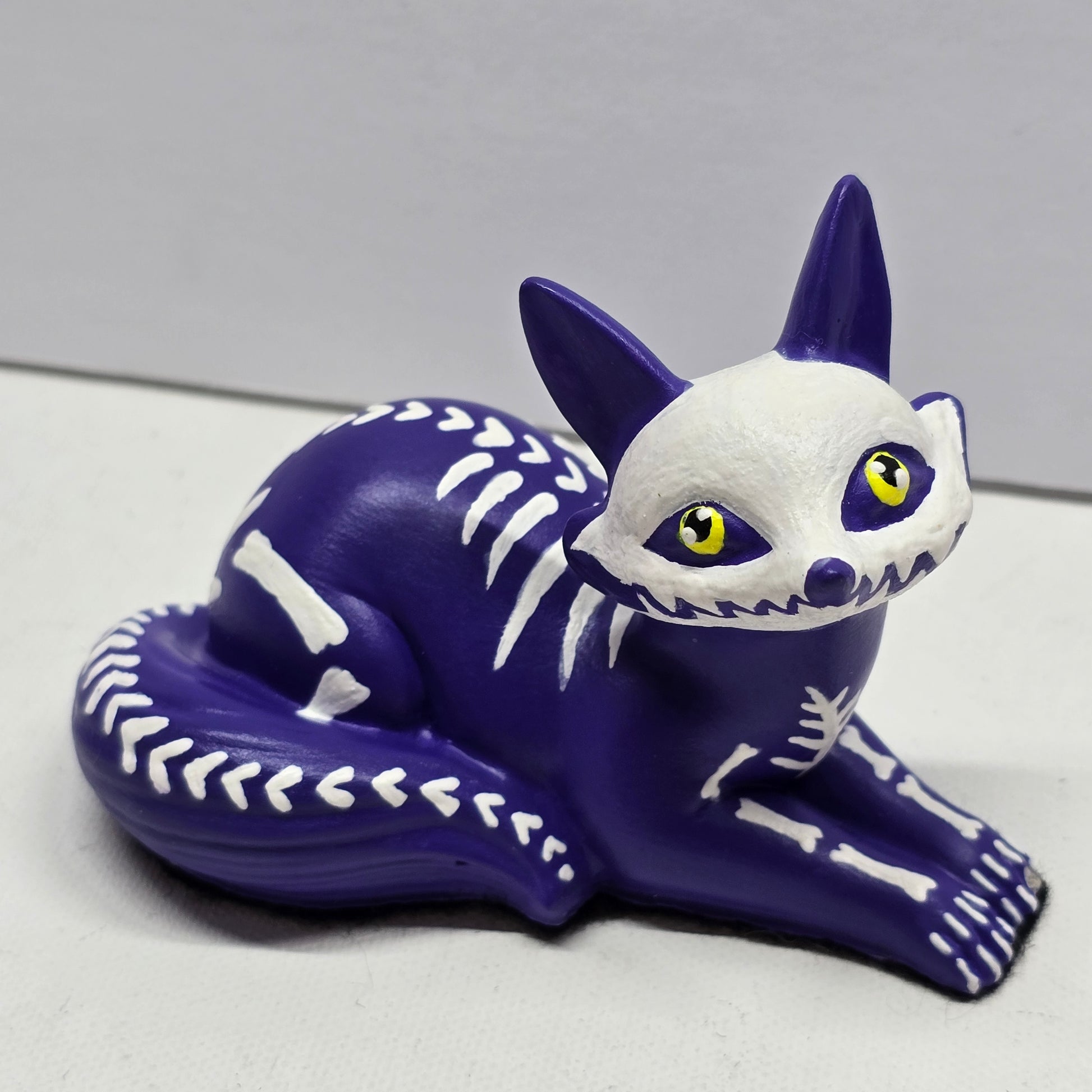 halloween fox, painted purple with white bone designs and featuring bright yellow pleading eyes