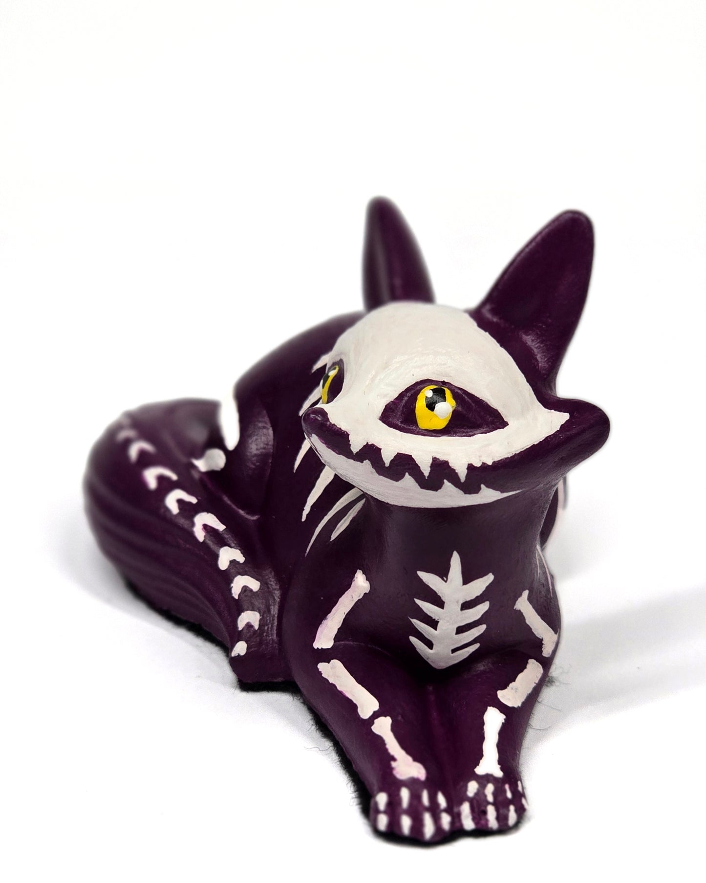 Purple skeleton puppy figurine with white bones on a white background