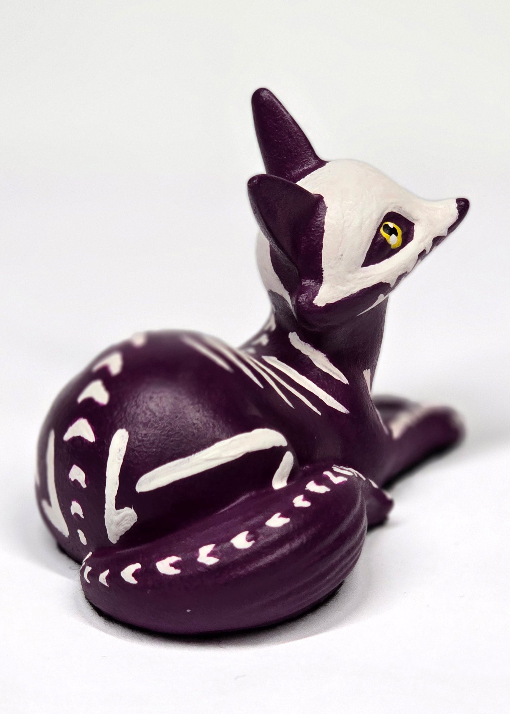 Purple skeleton puppy/fox/kit figurine on a white background