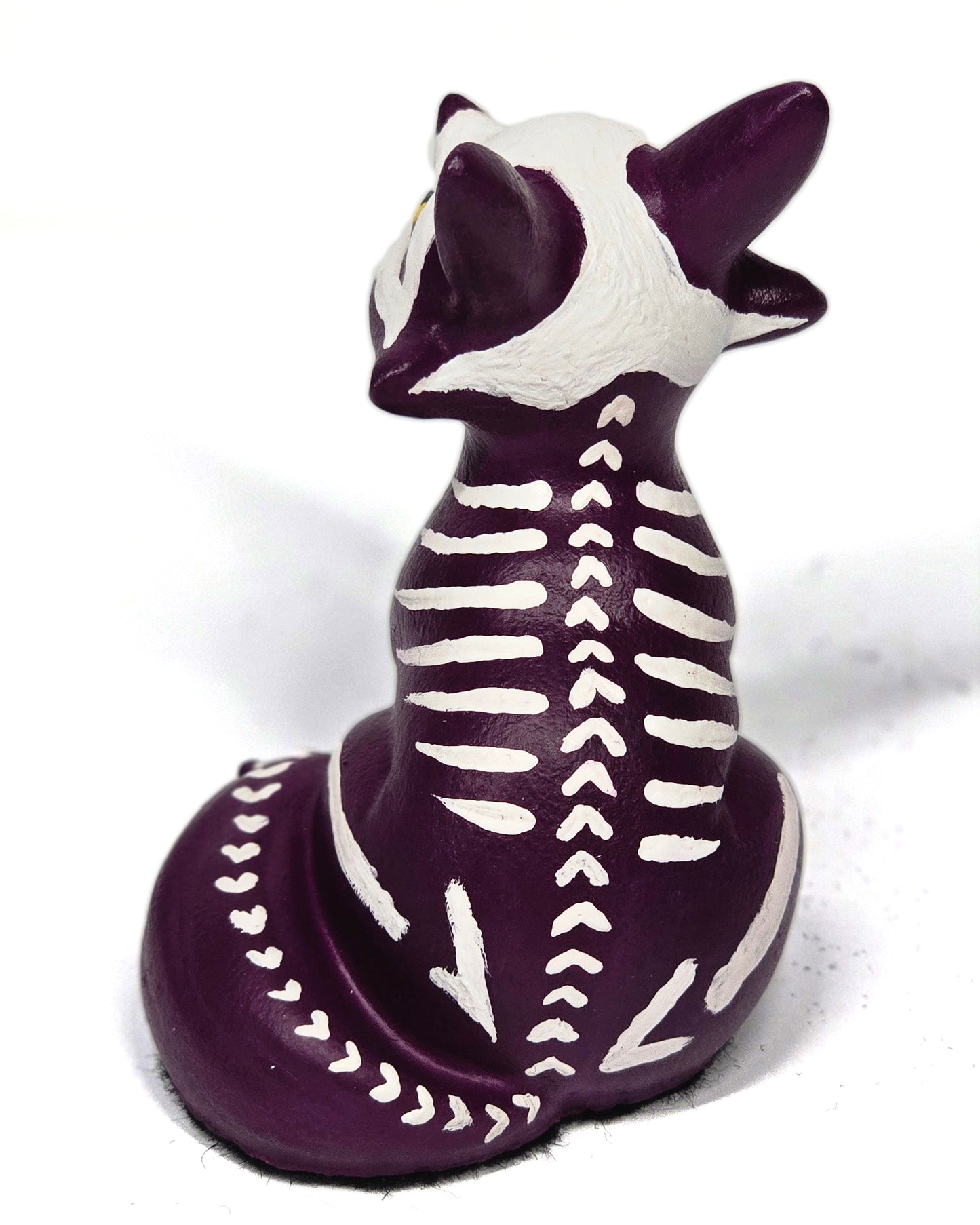 Skeletal fox figurine with purple and white colors on a white background