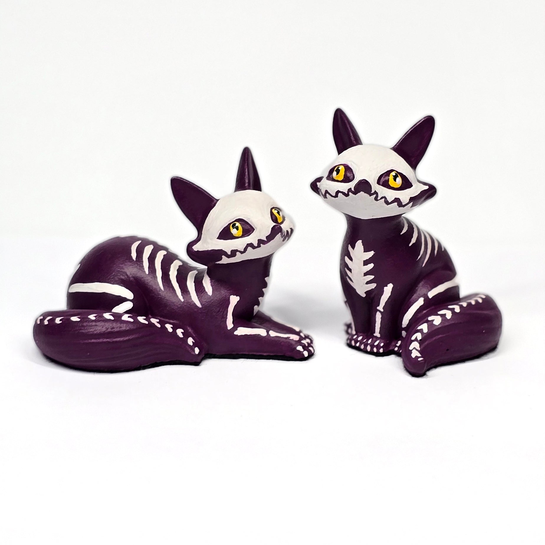 Two skeleton Fox puppy figurines on a white background